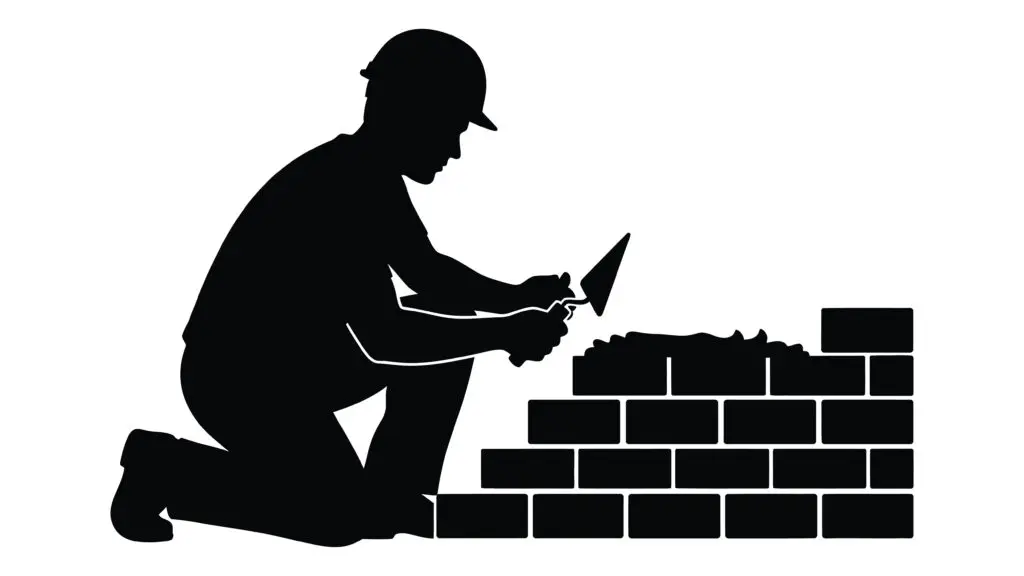 a man laying bricks on a wall